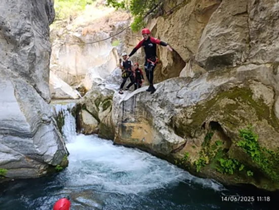 Participantes practicando barranquismo en un entorno natural cercano al Hostal Tolox, una experiencia de aventura en la Sierra de las Nieves