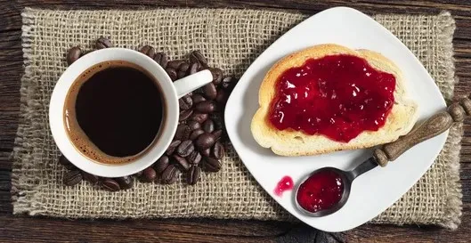Desayuno continental servido en el Hostal Tolox, con bollería, pan, embutidos y bebida caliente sobre una mesa preparada para los huéspedes
