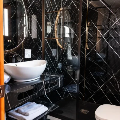 Vista general del baño en una habitación del Hostal Tolox, con lavabo, espejo y detalles funcionales para una estancia confortable