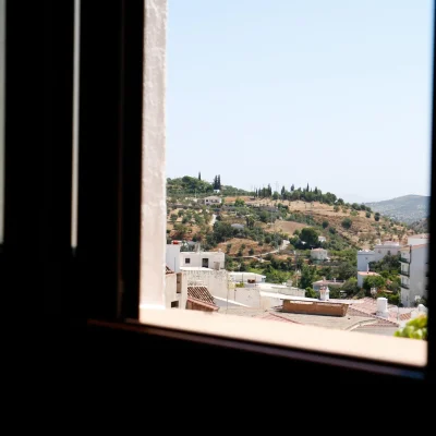 Vista del pueblo de Tolox a través de la ventana de un baño del Hostal Tolox, combinando comodidad interior con paisaje andaluz