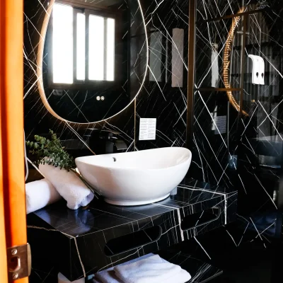 Vista completa del lavabo en el baño de una habitación del Hostal Tolox, con espejo, grifería moderna y toallas, en un entorno limpio y funcional