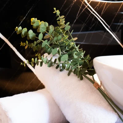 Toallas cuidadosamente colocadas junto al lavabo en el baño de una habitación del Hostal Tolox, reflejando atención al detalle y confort para el huésped