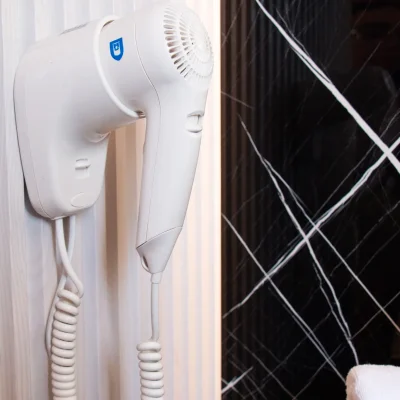 Secador de pelo instalado en el baño de una habitación del Hostal Tolox, pensado para ofrecer mayor confort a los huéspedes