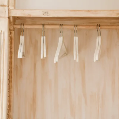 Armario abierto con perchas en el interior de una habitación del Hostal Tolox, ofreciendo espacio práctico para guardar ropa y equipaje