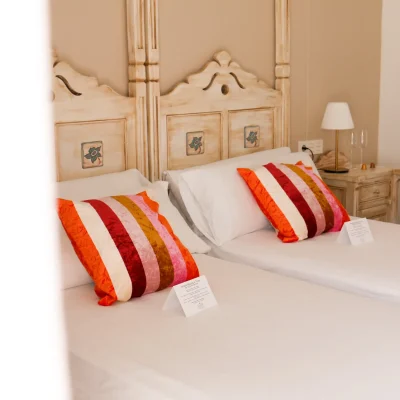 Habitación del Hostal Tolox con dos camas individuales, decoración sencilla y ambiente acogedor ideal para descansar en la Sierra de las Nieves