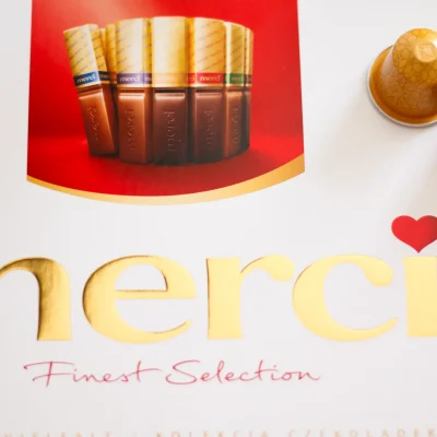 Caja de bombones con dos cápsulas de café colocadas encima, como detalle de cortesía en una habitación del Hostal Tolox en la Sierra de las Nieves