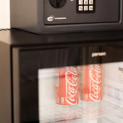 Detalle de una habitación del Hostal Tolox con caja fuerte y minibar, ofreciendo seguridad y confort a los huéspedes en la Sierra de las Nieves