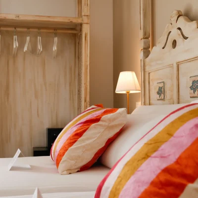 Habitación del Hostal Tolox con cama doble, decoración acogedora y mobiliario de estilo tradicional, ideal para descansar en la Sierra de las Nieves