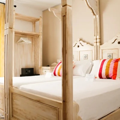 Habitación del Hostal Tolox con dos camas dobles, ideal para compartir estancia en un entorno cómodo y acogedor en la Sierra de las Nieves