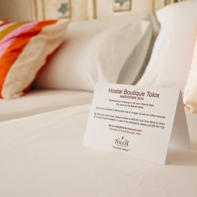 Cartel de 'bienvenidos' colocado sobre la cama en una habitación del Hostal Tolox, como detalle de cortesía para los huéspedes