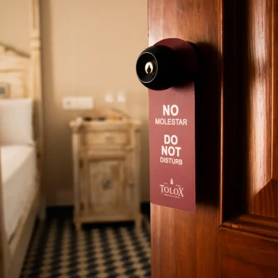 Cartel de 'no molestar' colgado en la puerta de una habitación del Hostal Tolox, señalando la solicitud de privacidad del huésped