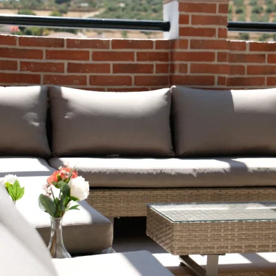 Vista de la terraza del Hostal Tolox con mobiliario exterior y ambiente relajado, perfecta para disfrutar del clima y entorno natural de la Sierra de las Nieves