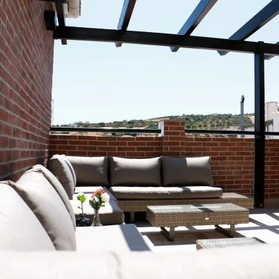 Zona de terraza del Hostal Tolox con mobiliario exterior, ideal para relajarse y disfrutar del clima y paisaje de la Sierra de las Nieves