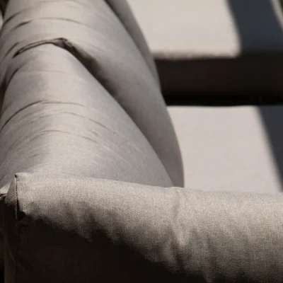 Sofá gris ubicado en la terraza del Hostal Tolox, espacio al aire libre ideal para descansar y disfrutar del entorno natural de la Sierra de las Nieves