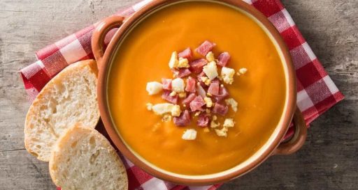 Plato de salmorejo tradicional con huevo duro servido sobre una mesa en el restaurante del Hostal Tolox, ejemplo de la cocina andaluza
